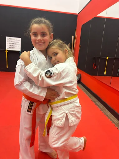 Compañerismo y abrazo entre alumnos de karate